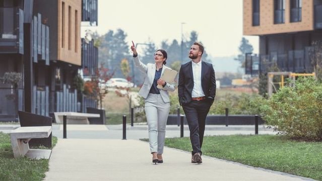 A real estate agent and real estate investor tour a residential complex that he would like to invest in.