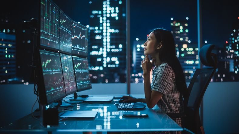 A private equity analyst looks at economic data while working late one night.