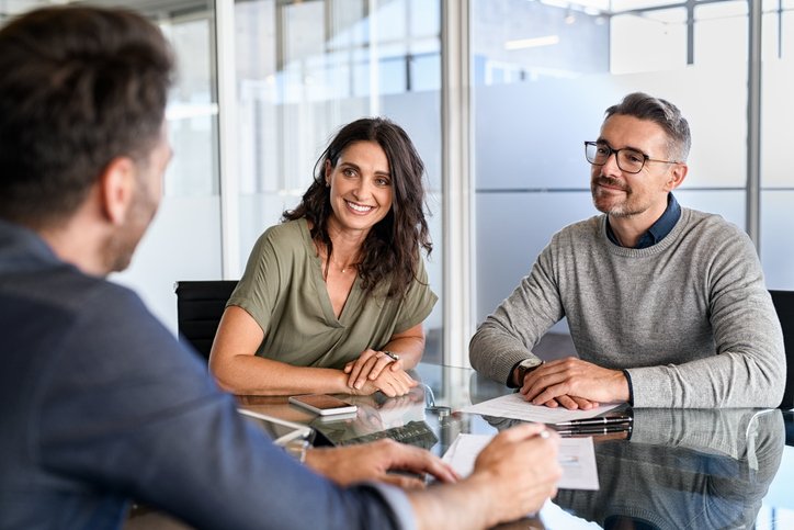 A couple discusses modern wealth creation methods with their financial advisor.