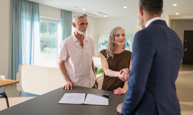 A couple meeting with a real estate broker to close on an investment.